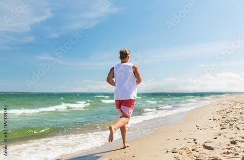 happy man running along summer beach © Syda Productions