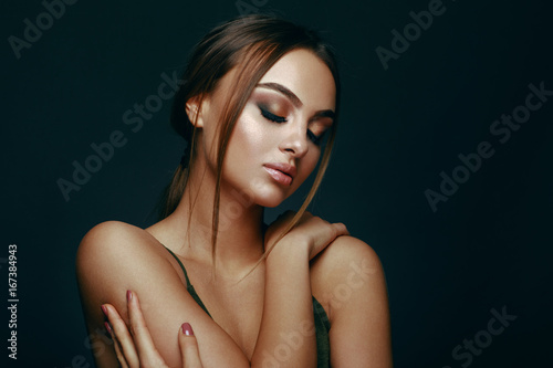 Beauty portrait of a young woman in the studio on a dark background