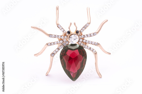 Golden spider with a big red stone isolated on white