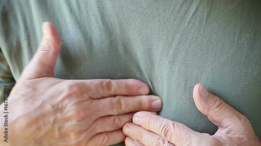 Senior man touches the areas of discomfort in his chest