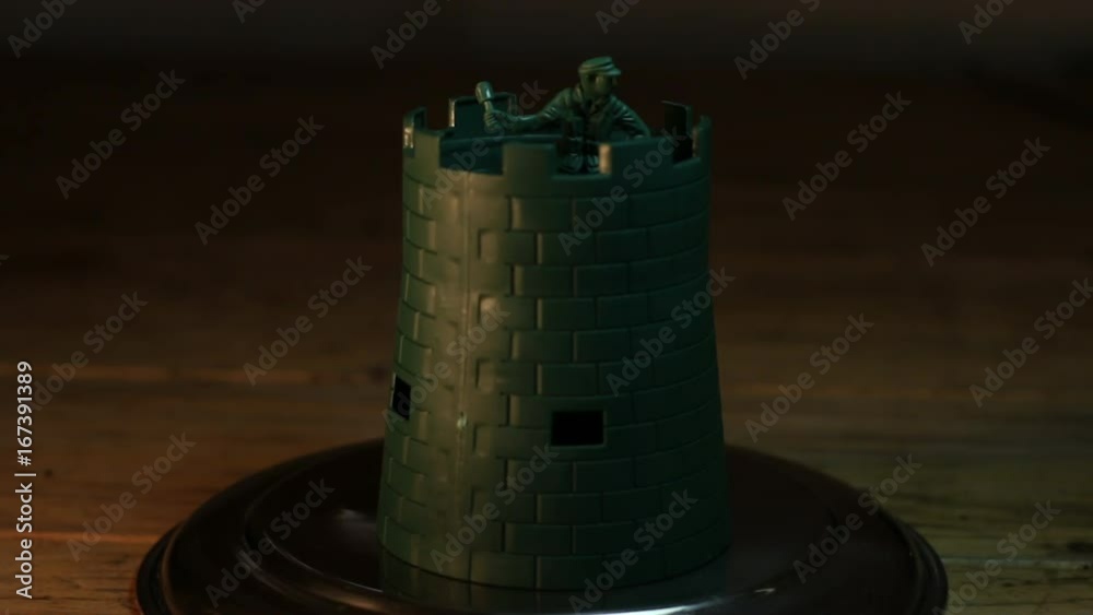 Hand places toy soldier and castle on display, close up Hand places toy soldier and castle on display, close up