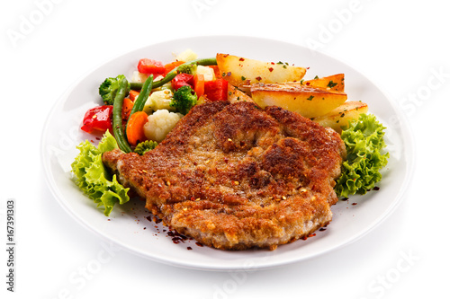Fried pork chop, baked potatoes and vegetable salad