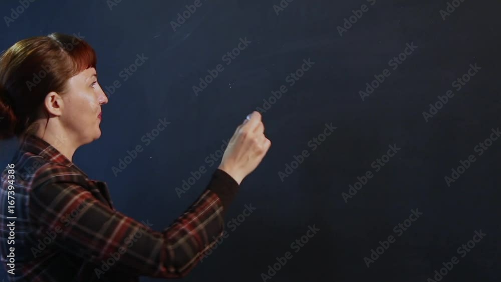 The English teacher of European appearance welcomes the students and turns to the blackboard to start writing with chalk. The English teacher of European appearance welcomes the students and turns to the blackboard to start writing with chalk.