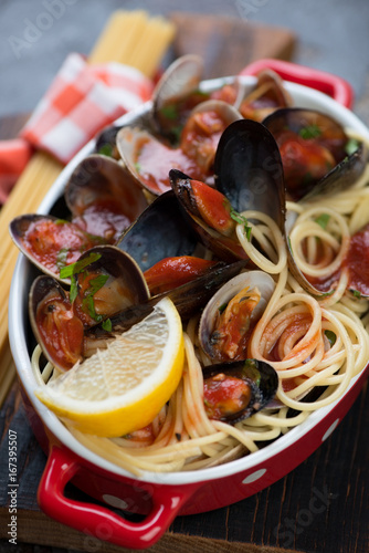 Close-up of spaghetti with vongole shells and mussels in tomato sauce, selective focus, shallow depth of field