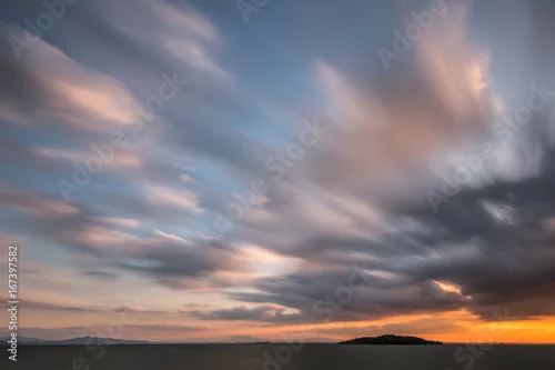 Obraz Piękny szeroki kąt, długi czas ekspozycji na jezioro o zachodzie słońca, z ogromnym niebem z ruchomymi chmurami
