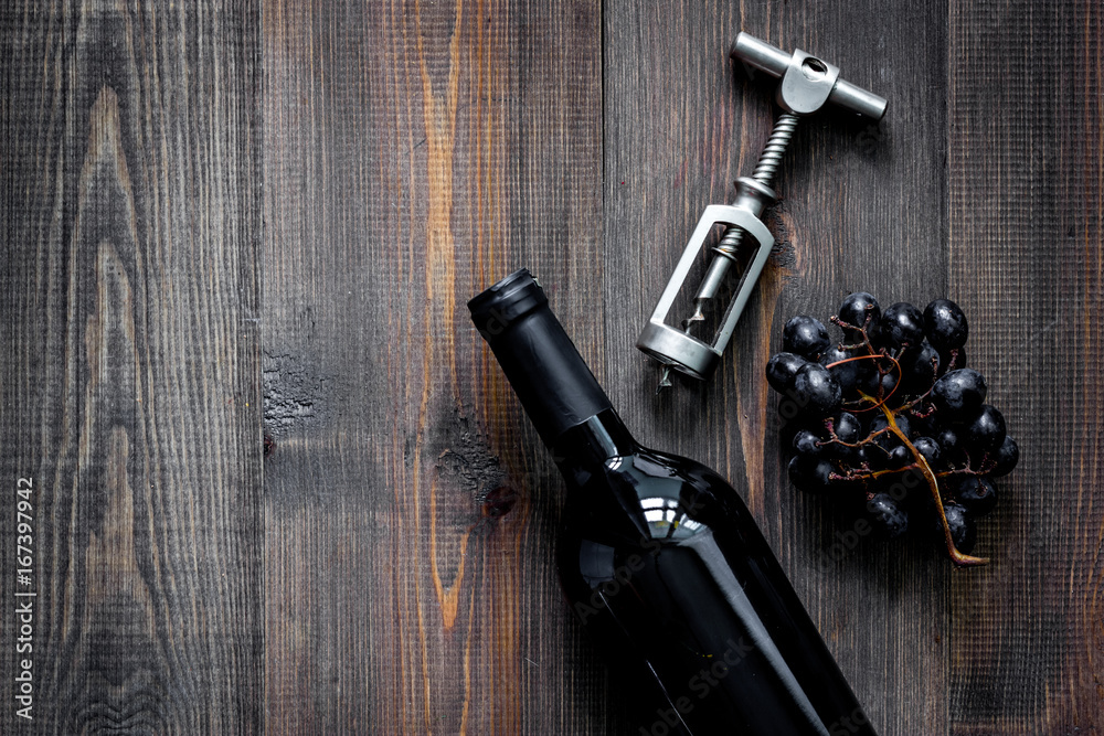 Open wine. Bottle and corkscrew on dark wooden table background top view copyspace Open wine. Bottle and corkscrew on dark wooden table background top view copyspace