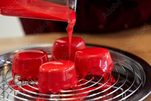 Billede på lærred jug pouring glaze to cakes at pastry shop