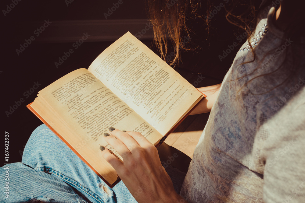 Obraz premium Spending free time by reading books. Girl reads avidly old interesting paper book. Natural light. Enjoy morning. Warm atmosphere. Knowledge, learning and education concept. Woman bookwarm. Close-up