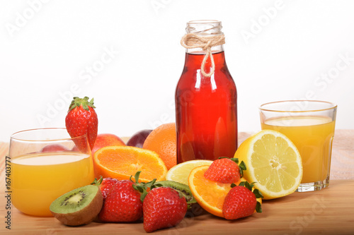 Orange juice in a glass and strawberry in a bottle