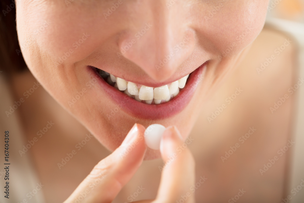 Fototapeta premium Close-up Of Female Taking White Pill