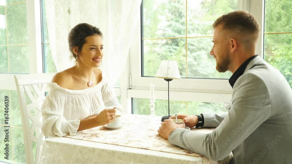 young couple smiling in a restaurant and talking