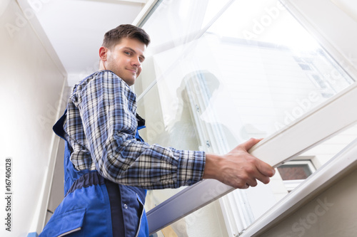 Male Repairman Installing Window