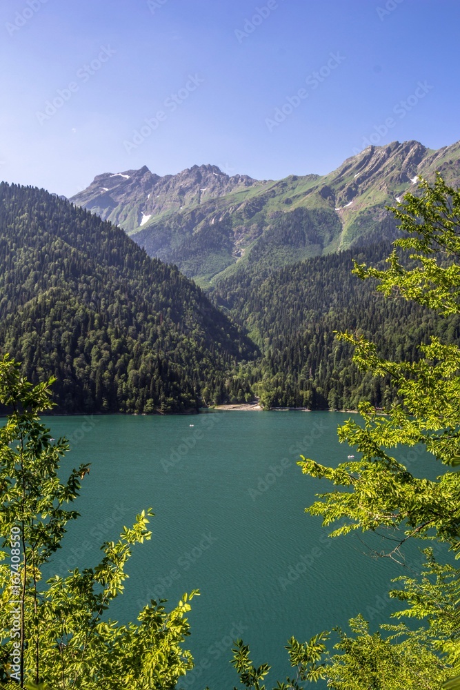 Красивый вид на живописное озеро между зелеными горными склонами. Панорама горной местности, летний сезон, Природа