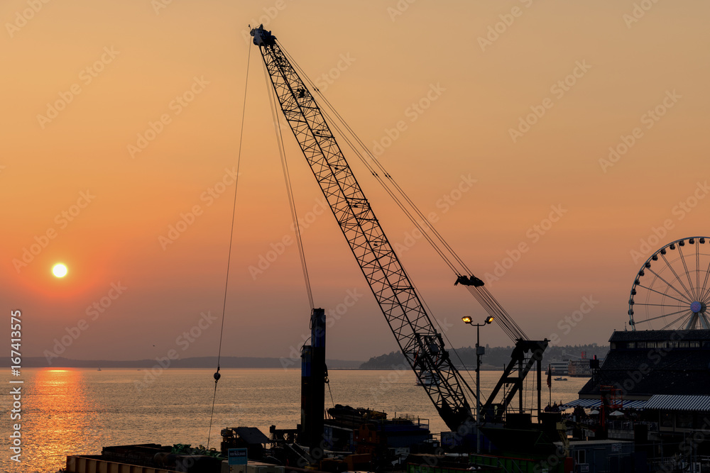 Seaside construction crane at sunset