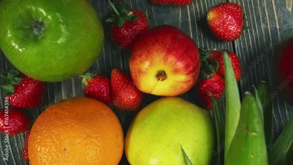 Close up of fresh fruits. Flat lay, top view, camera moving above the table. Pineapple, banana, apple, grape, strawberry, peach, orange Close up of fresh fruits. Flat lay, top view, camera moving above the table. Pineapple, banana, apple, grape, strawberry, peach, orange