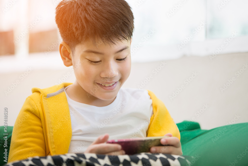 Happy asian boy using cell phone with smile face . Happy asian boy using cell phone with smile face .