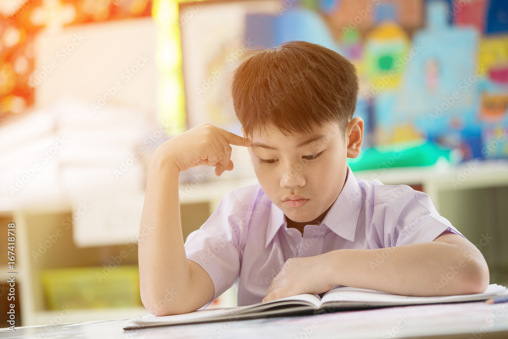 Happy asian child reading book with smile face at school . Happy asian child reading book with smile face at school .