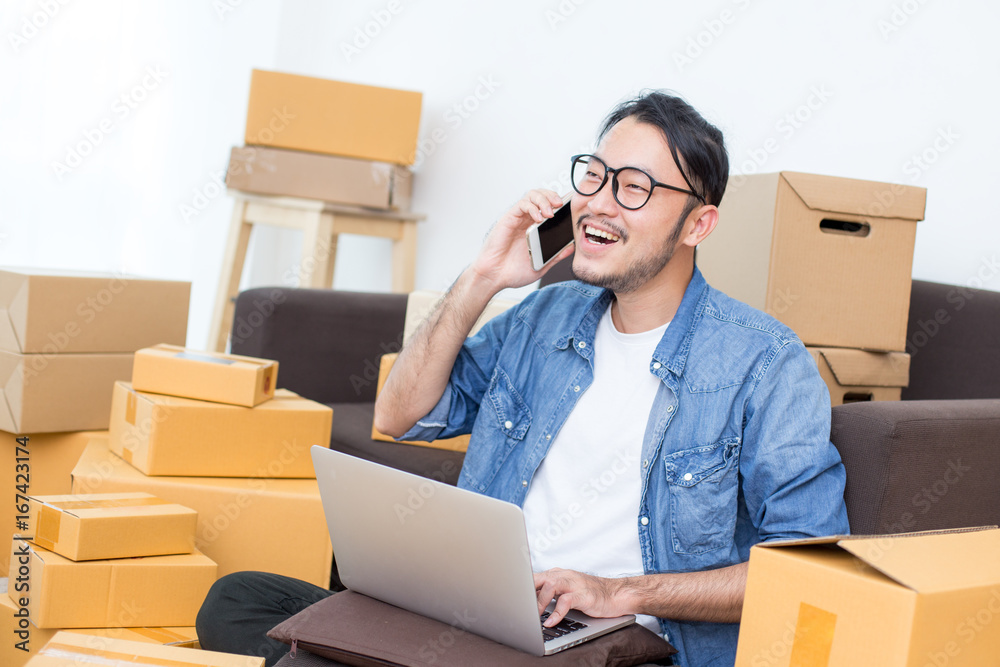 Young Asian Man using Smartphone for work at home, Young Owner Man receive Order form Customer , SME, Delivery, Man with Online Business or SME Concept. Young Asian Man using Smartphone for work at home, Young Owner Man receive Order form Customer , SME, Delivery, Man with Online Business or SME Concept.
