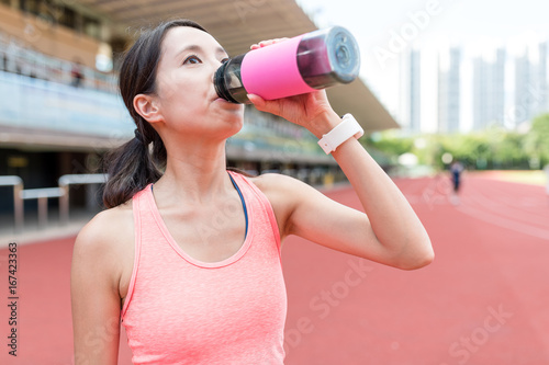Sport woman drinking water in sport stadium