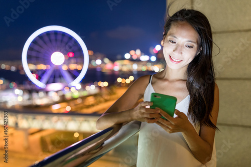 Woman looking at smart phone at night