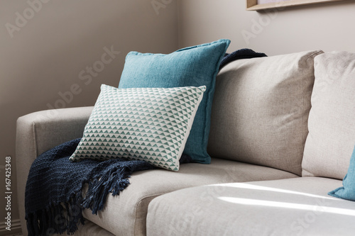 Close up of a fabric sofa with styled cushions and throw photo