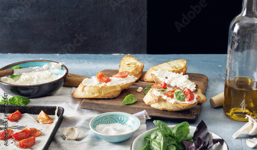 Italian bruschetta with baked tomatoes, basil and cheese