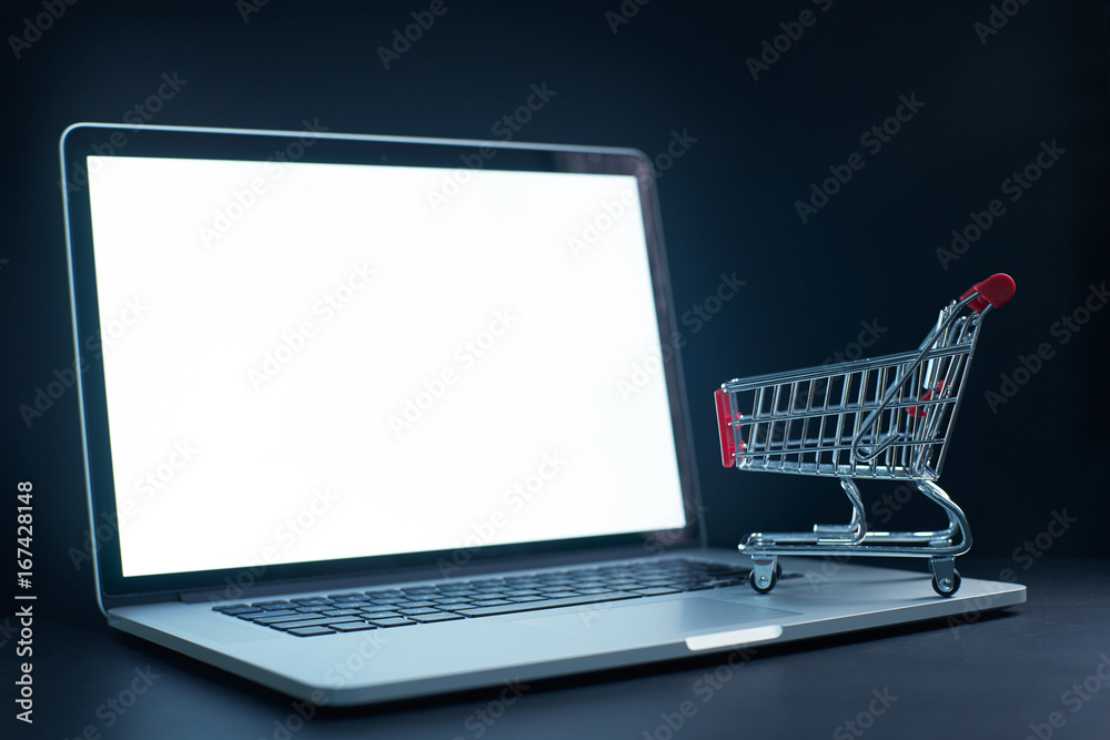 Shopping cart or trolley in front of Laptop , online marketing and business trading concept. Shopping cart or trolley in front of Laptop , online marketing and business trading concept.