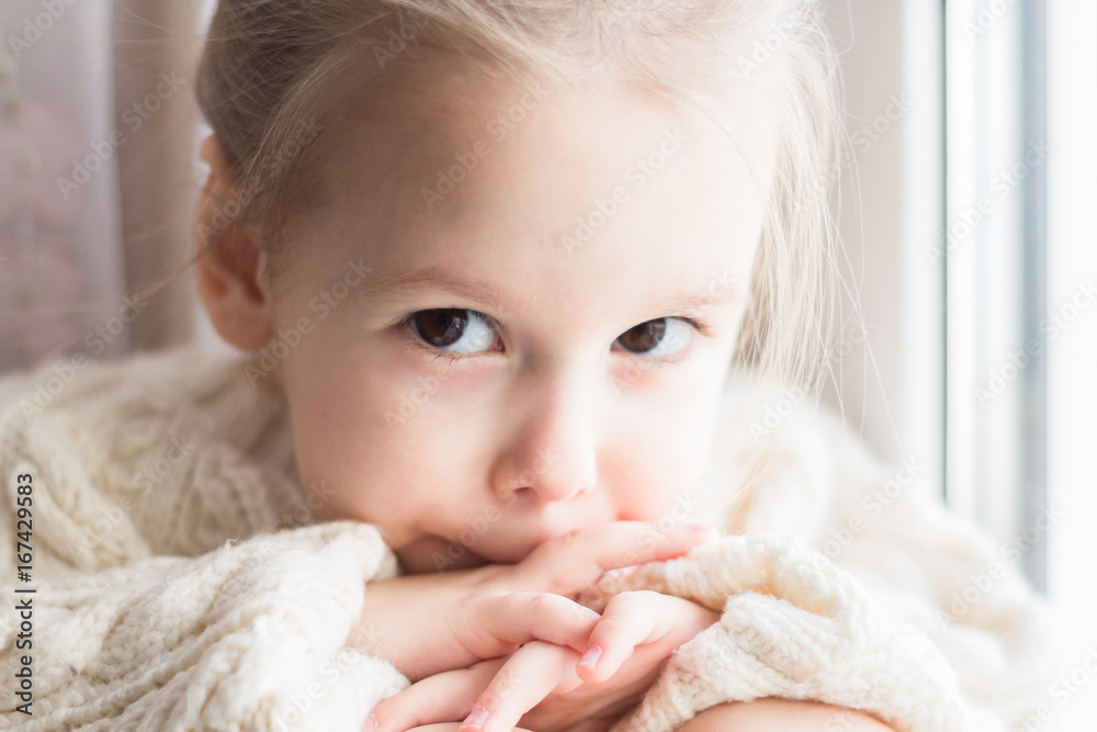A little girl in the white knitted sweater A little girl in the white knitted sweater