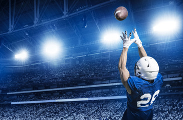 American Football Player Catching a touchdown Pass in a large stadium. View from below