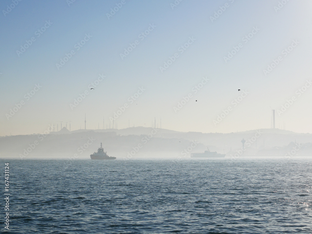Foggy morning scenery of Istanbul's Bosphorus strait in Turkey. The canal divides Istanbul into Asia part and Europe part, and is a famous tourist spot to take cruise along the canal.