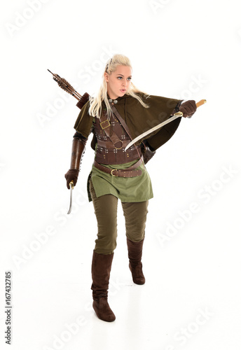  full length portrait of a blonde girl wearing green and brown medieval costume. standing pose isolated on white background.