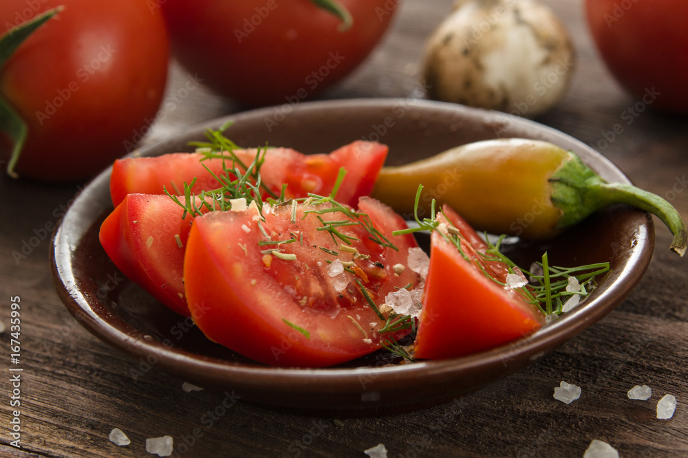 Ripe sliced tomatoes, hot chili peppers, garlic on a wooden table Ripe sliced tomatoes, hot chili peppers, garlic on a wooden table