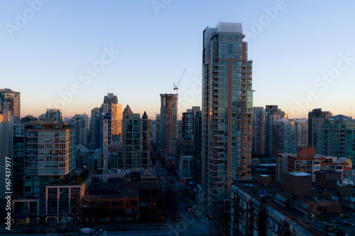 Morning cityscape with sunrise illuminating top of building