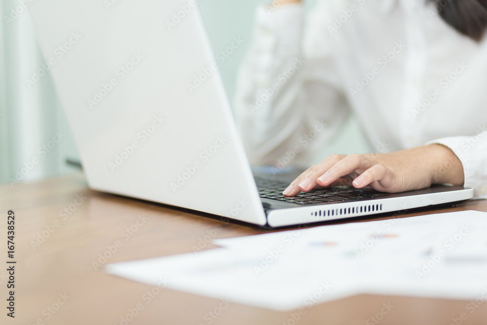 Young business woman working on laptop in office. Young business woman working on laptop in office.