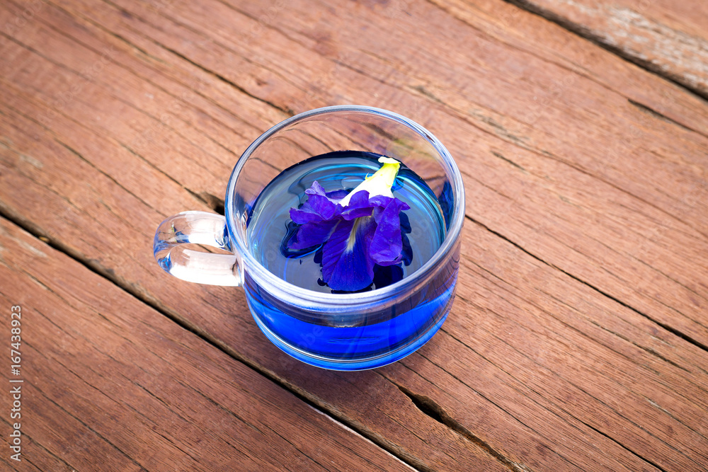 Butterfly pea in cup on wood background Butterfly pea in cup on wood background
