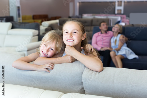 Portrait of two smiling sisters is happying of new sofa