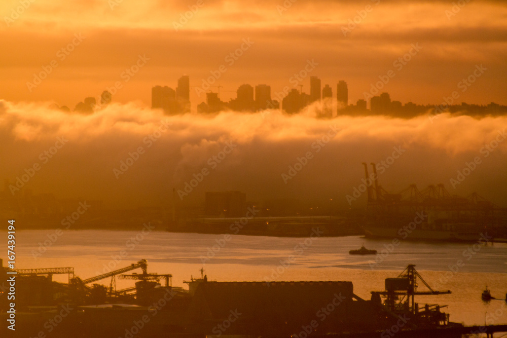Colorful sunrise in city in clouds and fog