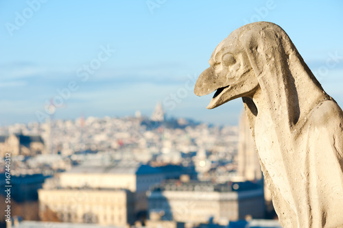 Gargoyle against blue sky in Paris, France