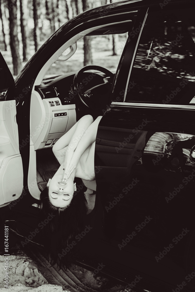 Fashionable attractive and sexy female in car. The sexual young naked