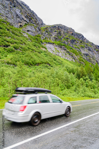 Car driving in rainy mountain landscape on wet road. © imfotograf