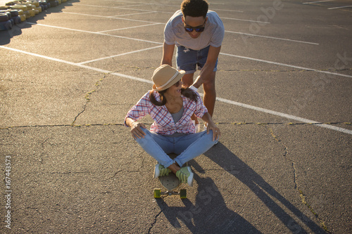 Young couple riding skateboard during sunrise  photo