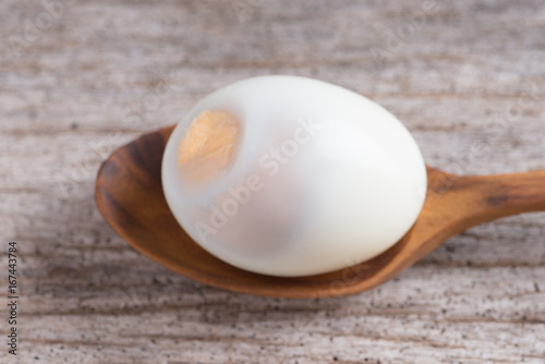 Peeled boiled egg on wood background