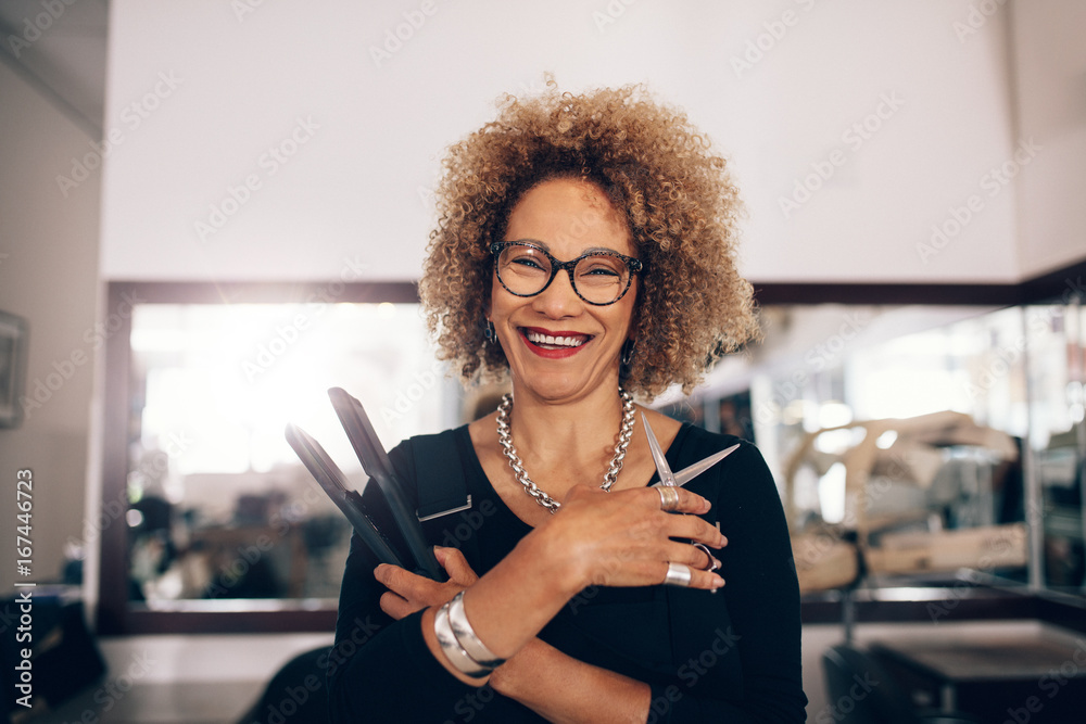 Φωτογραφία Female hairdresser at the salon holding hairdressing accessories