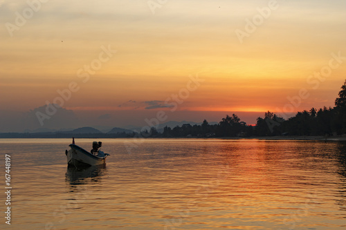 Orange sunset on the sea with a small boat  Thailand