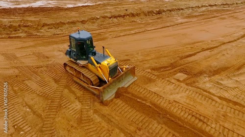 Mining machinery. Bulldozer machine. Aerial view of crawler bulldozer mining sand at quarry. Bulldozer at industrial area. Sky view of mining machinery working at sand quarry. Earth moving equipment