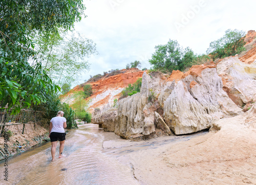 Mui Ne, Vietnam - February 19th, 2017: Tourists visit spring in ecotourism on spring day, mountain here unstructured natural stone beautiful by erosion of natural landscapes drawn in Mui Ne, Vietnam