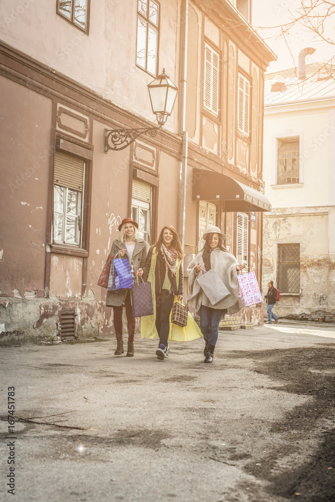 Naklejka premium Three best friends walking on the street . Three best friends returning from shopping.