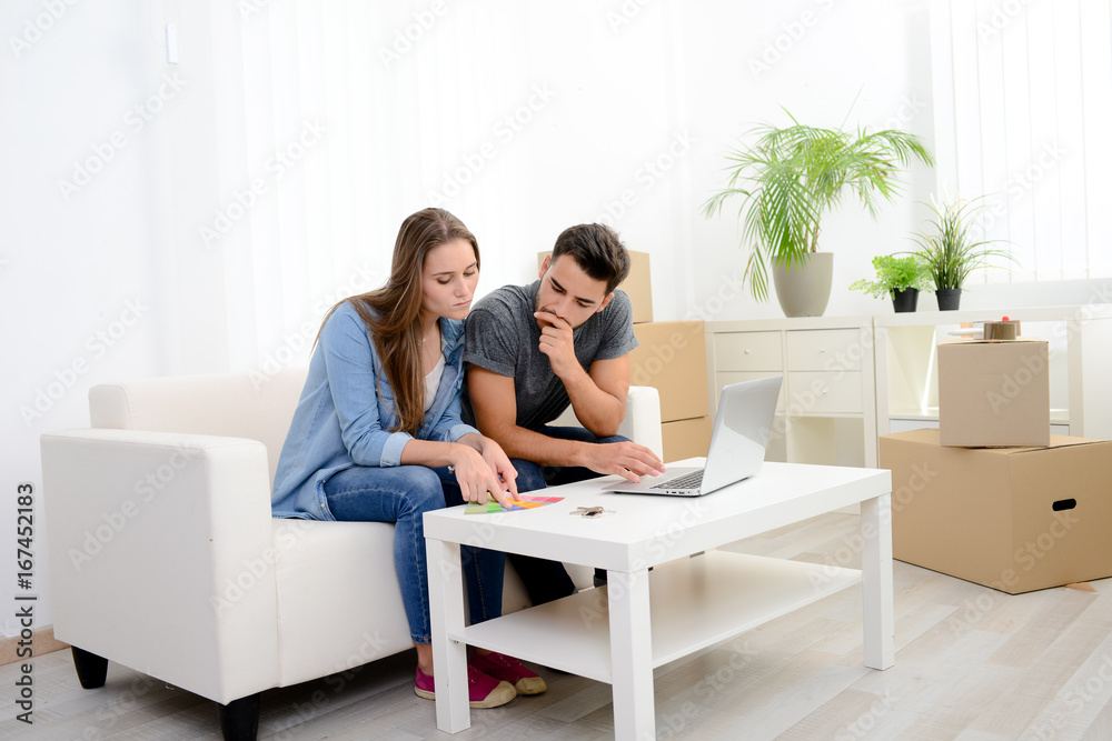 happy young couple student roommate making future project with internet computer at home while packing boxes and moving furnitures during move into their new home flat apartment happy young couple student roommate making future project with internet computer at home while packing boxes and moving furnitures during move into their new home flat apartment