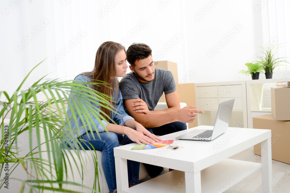 happy young couple student roommate making future project with internet computer at home while packing boxes and moving furnitures during move into their new home flat apartment happy young couple student roommate making future project with internet computer at home while packing boxes and moving furnitures during move into their new home flat apartment
