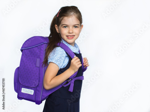 Obraz na płótnie Cute smiling schoolgirl in uniform with school bag isolated on white background, 1 september w salonie